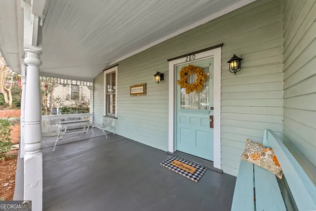 a view of a house with a yard and large trees