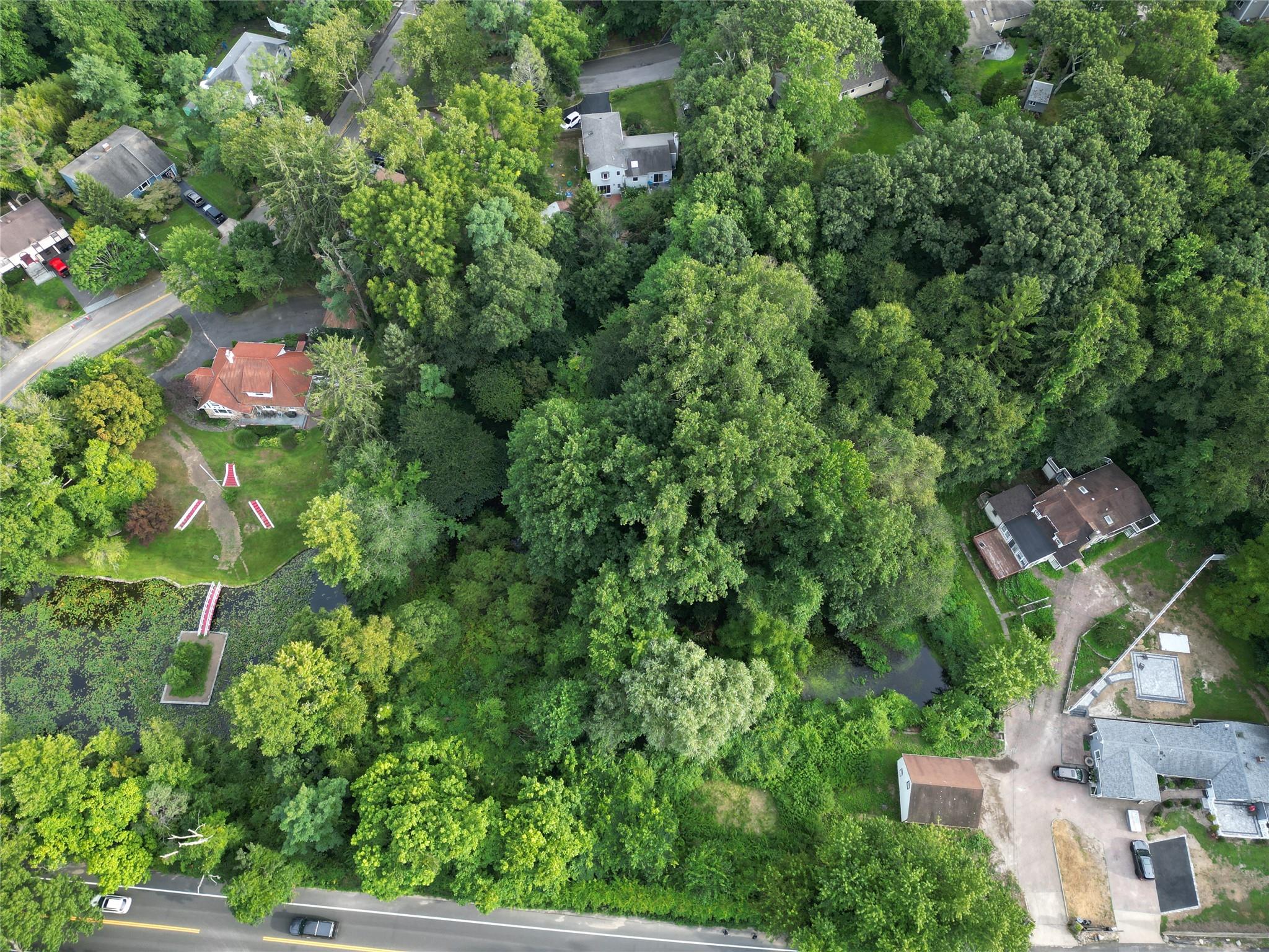 an aerial view of residential house with outdoor space and trees all around