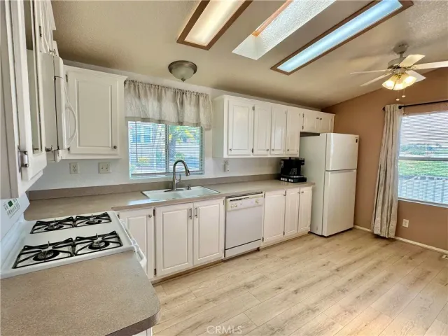 a kitchen with white cabinets and white appliances