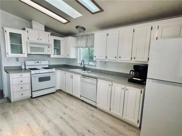 a kitchen with stainless steel appliances a white cabinets and sink