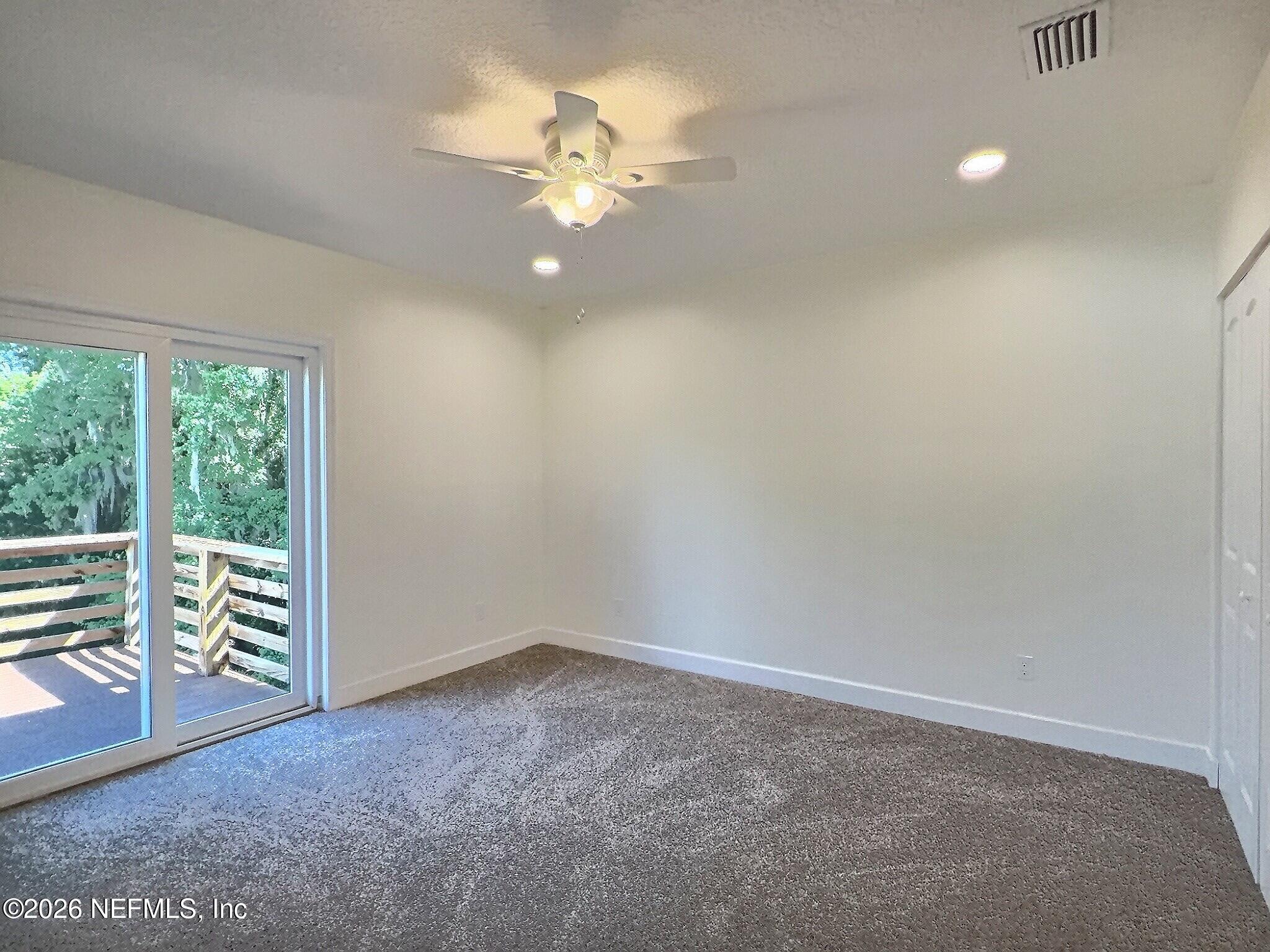 159 Mays Cove Road East Palatka, FL 32131 - Photo 51 of 62 en empty room with windows and ceiling fan