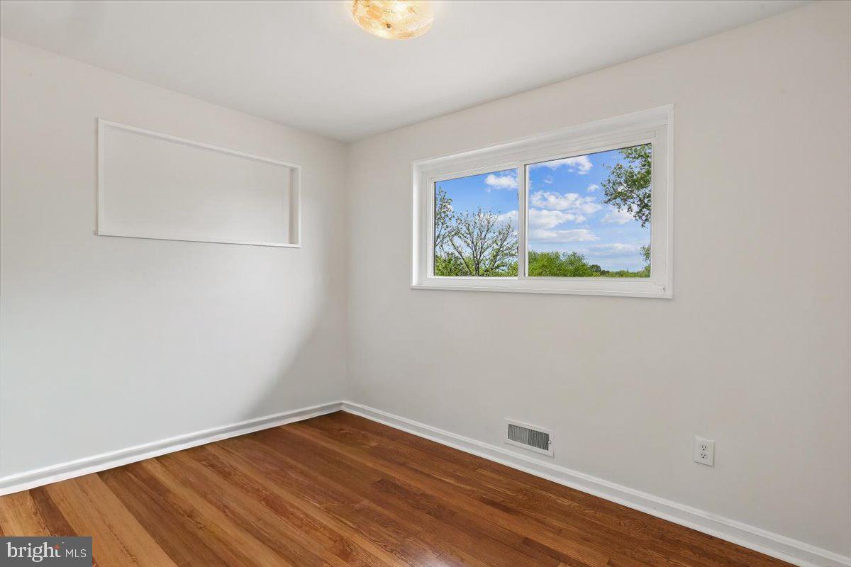 3709 Kenway Street Silver Spring, MD 20906 - Photo 26 of 34 a view of an empty room with wooden floor and a window