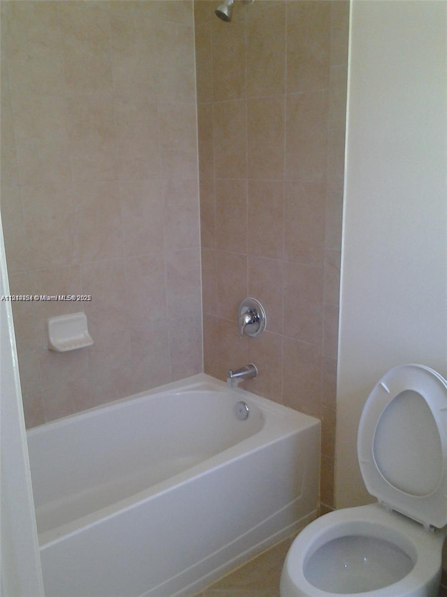 3217 Southeast 4th Street Homestead, FL 33033 - Photo 16 of 20 a white bath tub sitting next to a toilet