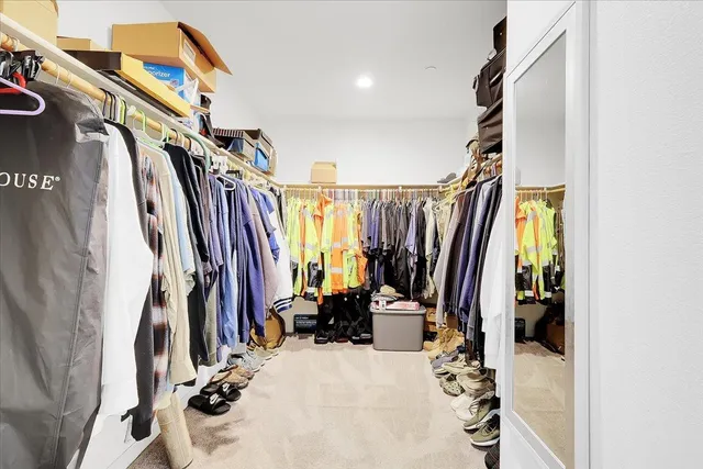 a view of walk in closet with clothes and shoes