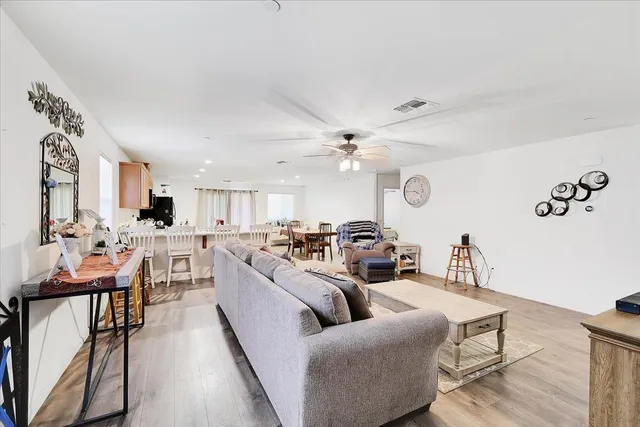 a living room with furniture kitchen view and a window