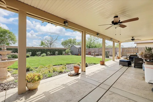 a living room with a floor to ceiling window next to a yard
