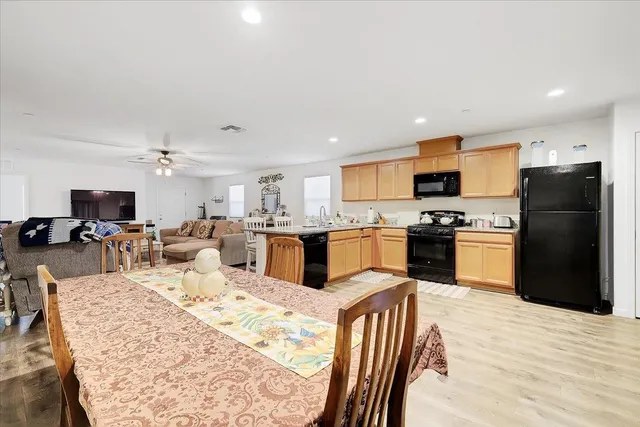 a kitchen with stainless steel appliances kitchen island granite countertop a refrigerator a stove top oven and a sink with cabinets