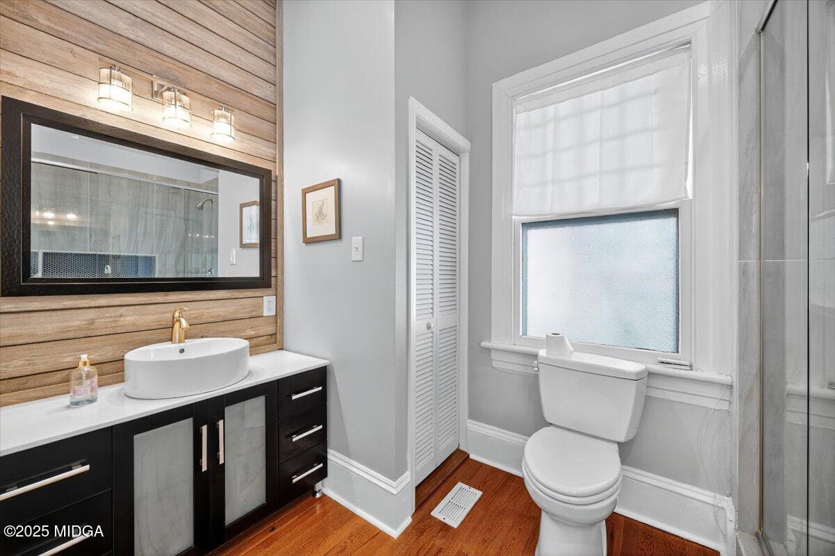 173 Pierce Avenue Macon, GA 31204 - Photo 13 of 20 a bathroom with a toilet a sink a mirror a window and vanity
