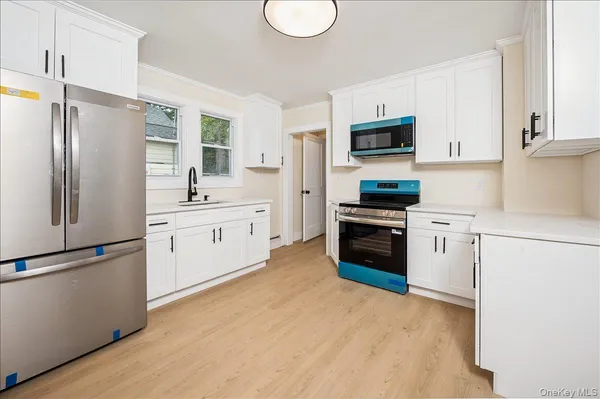 a kitchen with white cabinets and stainless steel appliances