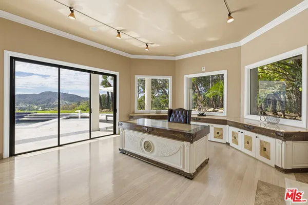 a living room with a large window and a chandelier