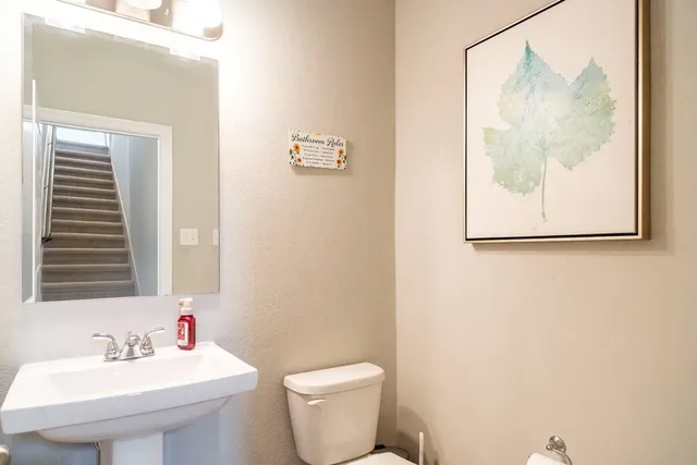 a bathroom with a toilet sink and mirror