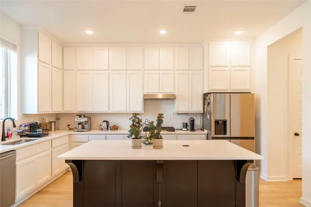 a kitchen with kitchen island a sink stainless steel appliances and cabinets
