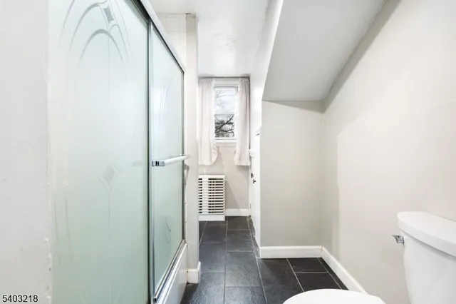 a view of a hallway with wooden floor and entryway