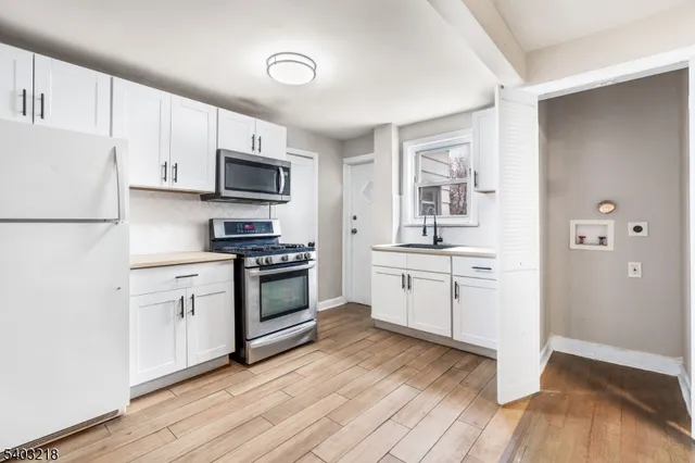 a kitchen with granite countertop white cabinets and stainless steel appliances
