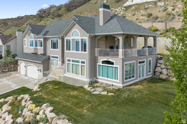 708 Eagle Rdg Drive Bountiful, UT 84010 - Photo 66 of 69 Multi-level residence featuring a four-car garage, extensive window placement, and a covered upper-level balcony with metal railings