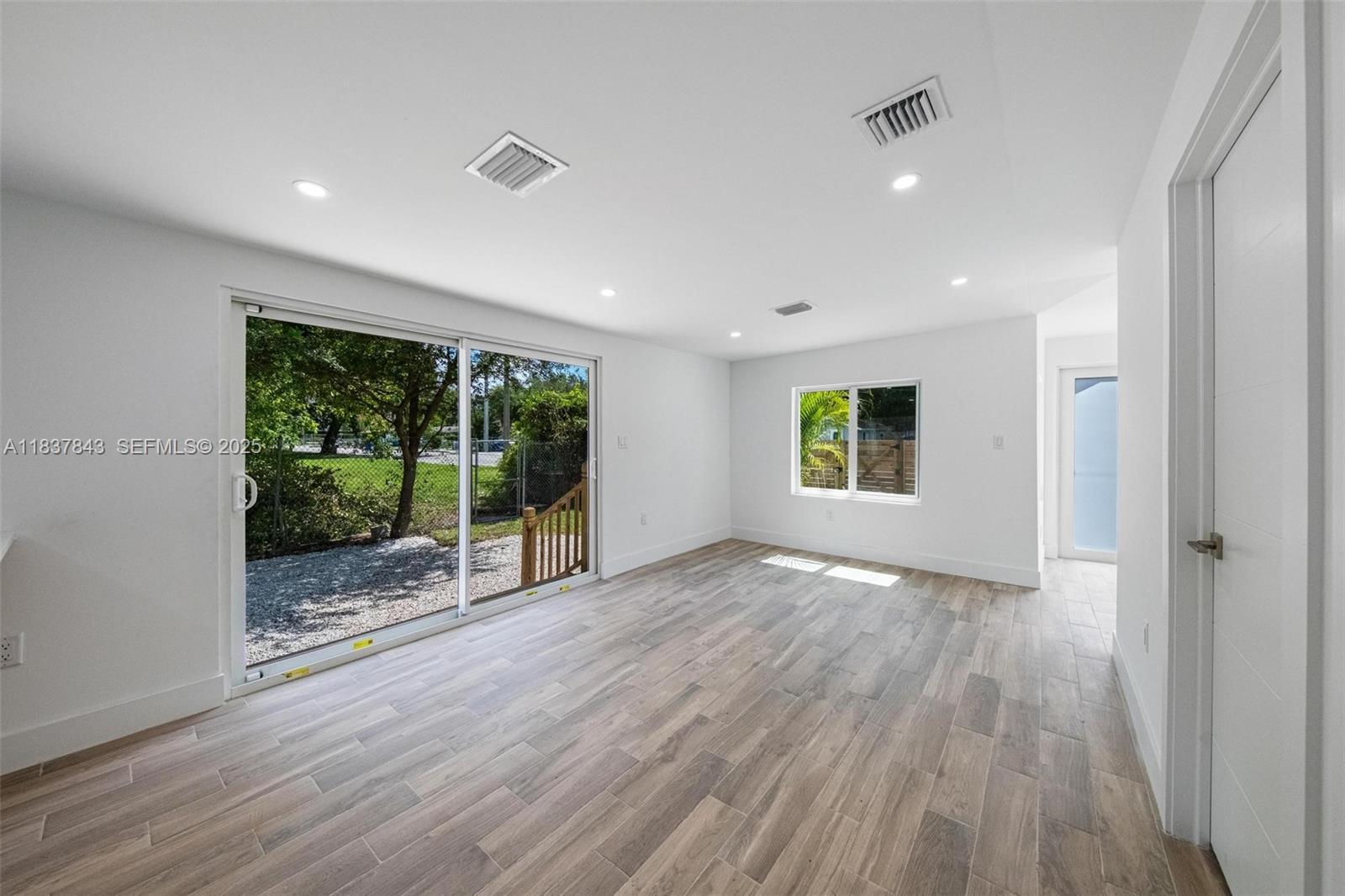 5900 Northwest 5th Court Miami, FL 33127 - Photo 12 of 35 a view of an empty room with wooden floor and a window