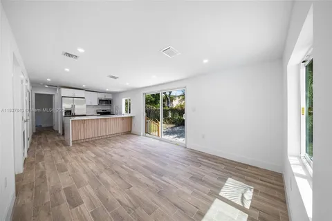 a view of kitchen with wooden floor and electronic appliances