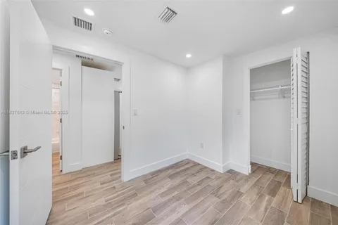 a view of empty room with wooden floor