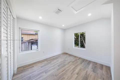 an empty room with a window and wooden floor