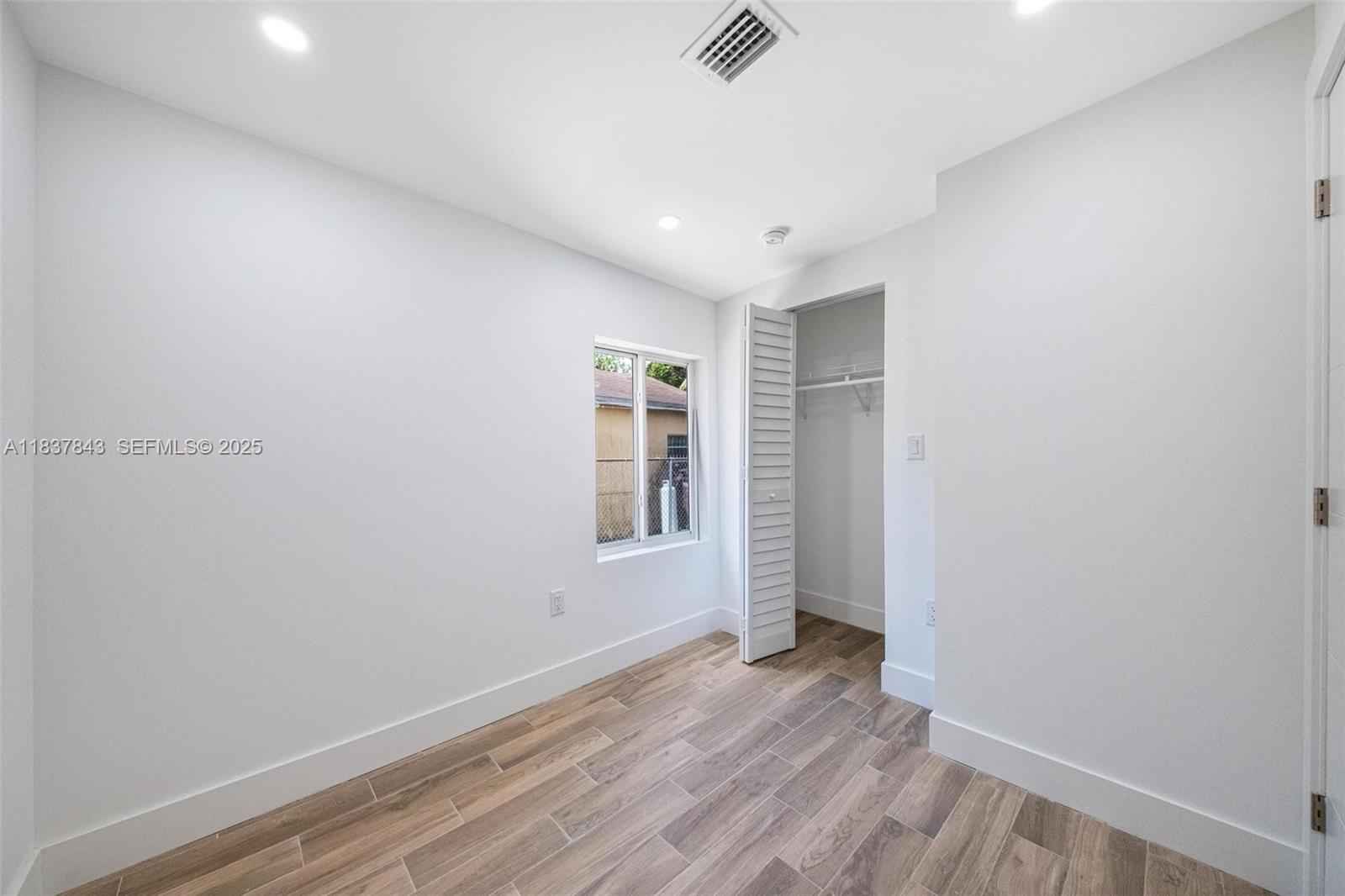 5900 Northwest 5th Court Miami, FL 33127 - Photo 25 of 35 an empty room with wooden floor and windows