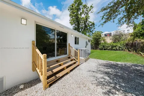 a view of backyard with deck and a garden