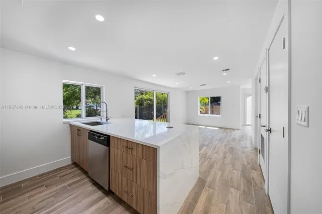 a view of a kitchen with a sink and wooden floor