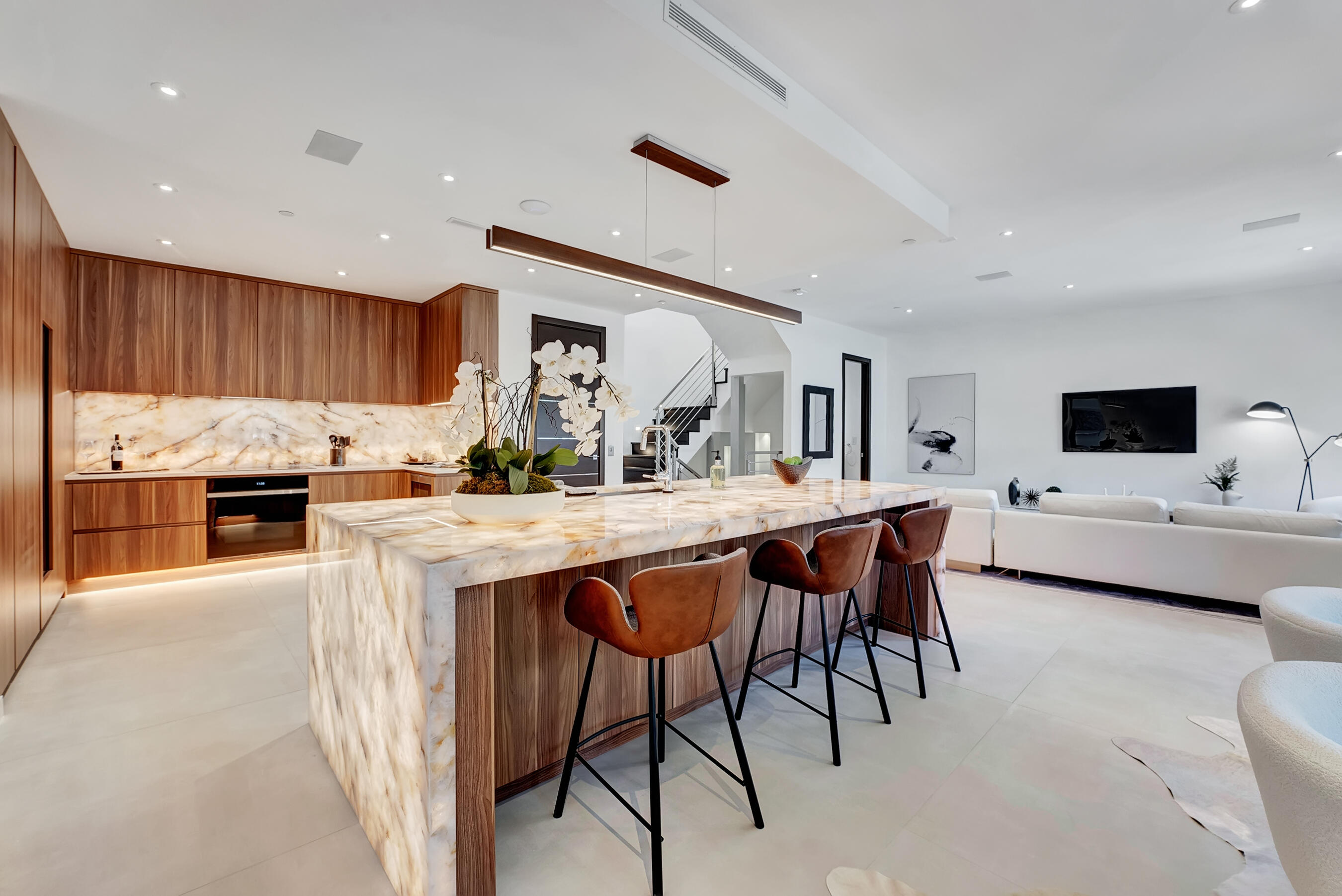 a kitchen with stainless steel appliances kitchen island granite countertop a table chairs sink and cabinets