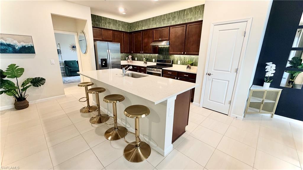 2085 Yellowfin Circle Naples, FL 34114 - Photo 11 of 50 a kitchen with a sink a refrigerator and a stove