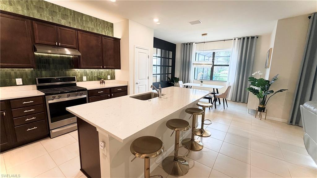 2085 Yellowfin Circle Naples, FL 34114 - Photo 12 of 50 a kitchen with a table chairs and a stove