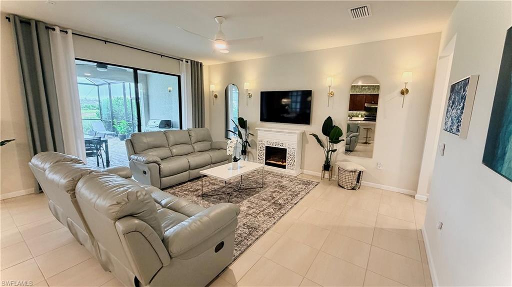 2085 Yellowfin Circle Naples, FL 34114 - Photo 13 of 50 a living room with furniture a flat screen tv and a large window