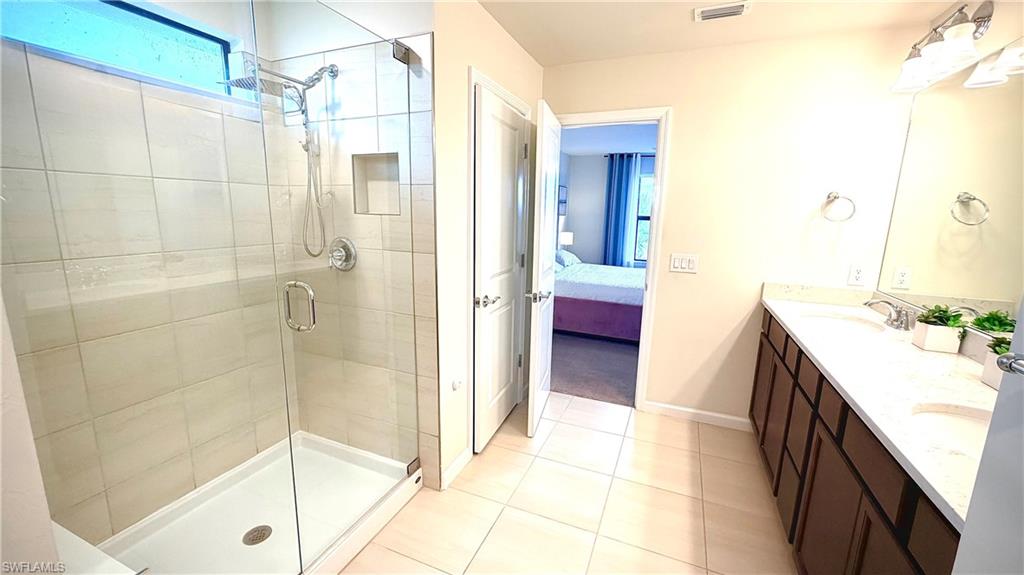 2085 Yellowfin Circle Naples, FL 34114 - Photo 32 of 50 a bathroom with a tub a sink and a glass door shower
