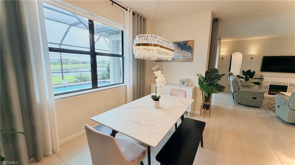 2085 Yellowfin Circle Naples, FL 34114 - Photo 9 of 50 a living room with furniture a flat screen tv and a large window