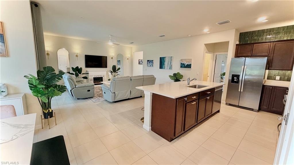 2085 Yellowfin Circle Naples, FL 34114 - Photo 47 of 50 a living room with couches a flat screen tv and a refrigerator