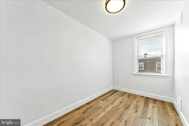 a view of a room with wooden floor and white walls