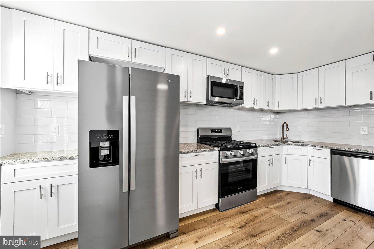 1232 Edgehill Road Darby, PA 19023 - Photo 8 of 20 a kitchen with stainless steel appliances a refrigerator stove and microwave