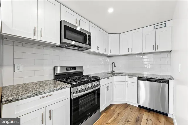a kitchen with stainless steel appliances granite countertop a stove and a microwave