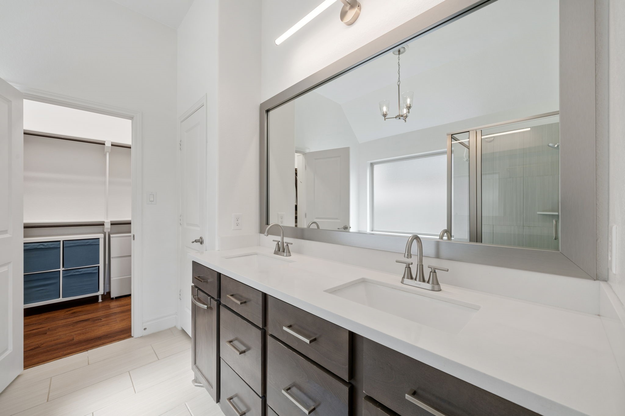 2119 Blackhawk Ridge Lane Manvel, TX 77578 - Photo 17 of 49 Primary Bathroom
Spa-inspired primary bathroom with expansive dual-sink dark vanity, quartz countertops, brushed nickel fixtures, glass-enclosed shower, and direct access to the walk-in closet.