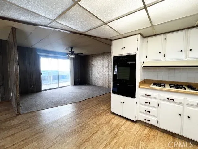 a kitchen with cabinets and wooden floor