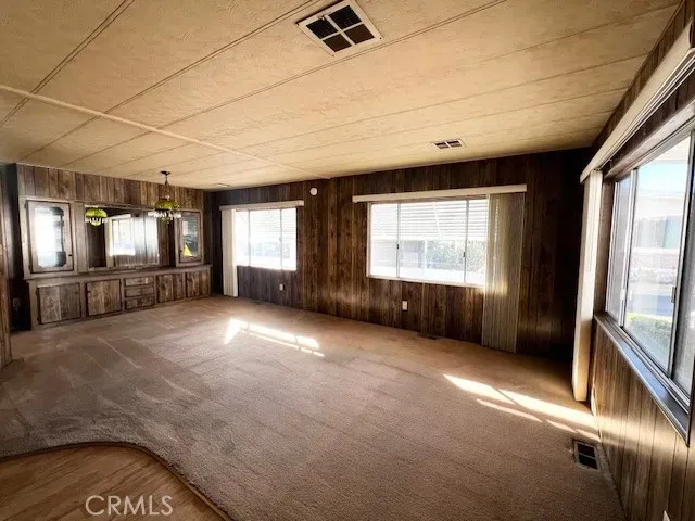 a view of an empty room with a fireplace and a window