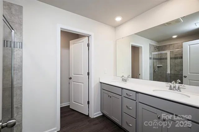 a bathroom with double vanity sinks and a mirror