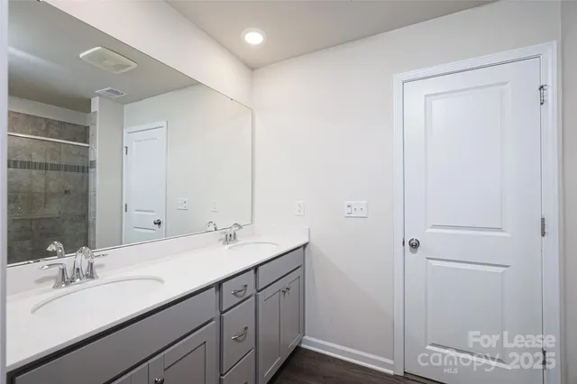 a bathroom with a double vanity sink and a mirror