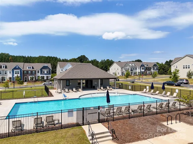 a view of a swimming pool with a lawn chairs under an umbrella