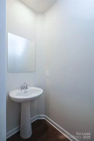 a white sink sitting under a bathroom mirror