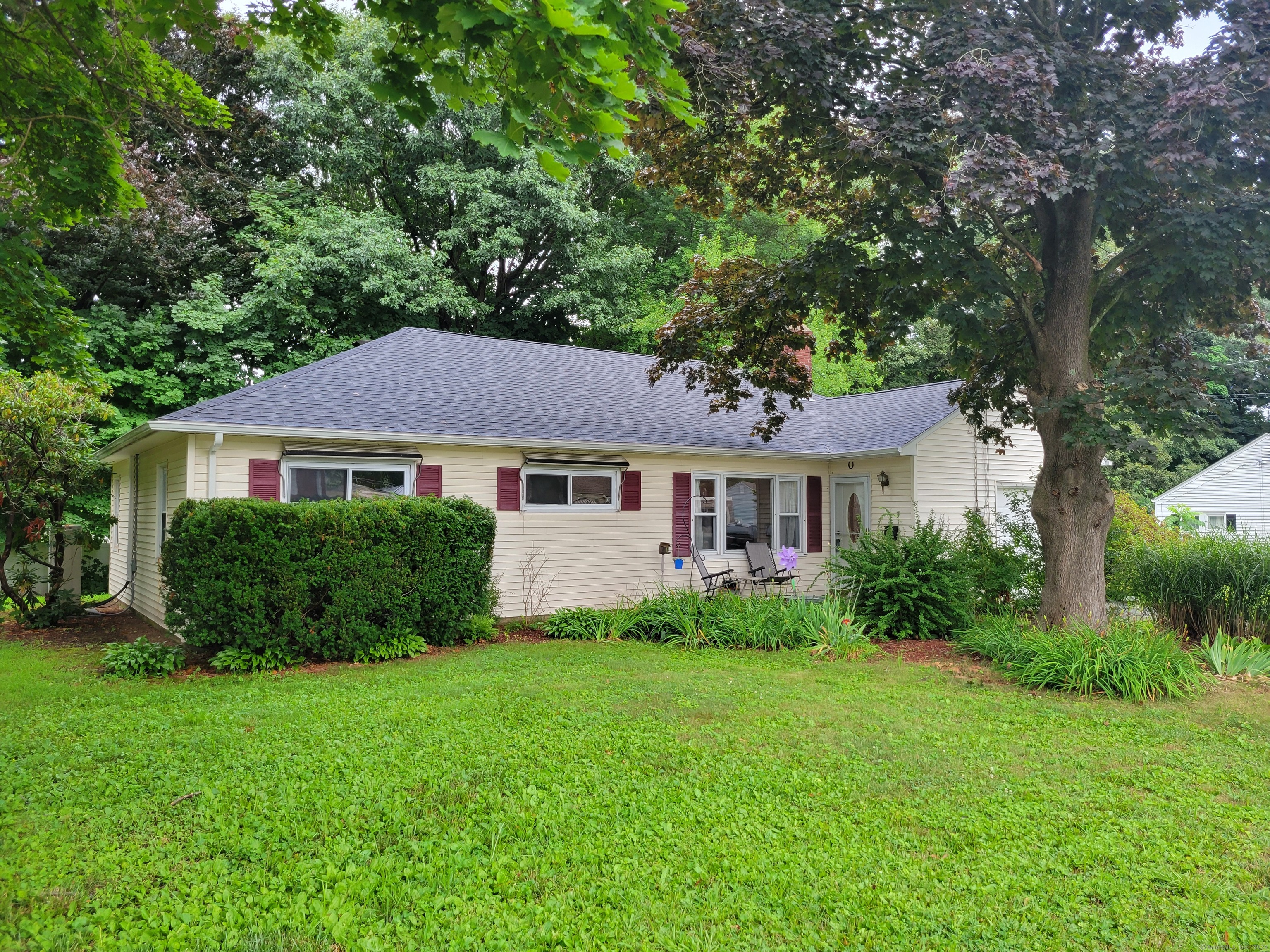 57 Milford Road Manchester, CT 06042 - Photo 1 of 1 a front view of a house with a garden and trees