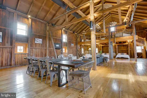a dining room with wooden floor glass table and chairs