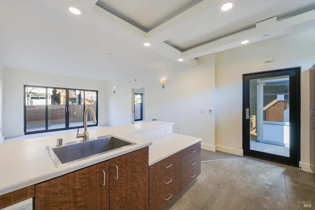 a large kitchen with stainless steel appliances a sink and a large window