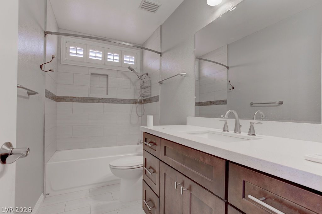 1416 Walstone Road North Las Vegas, NV 89031 - Photo 19 of 47 A well-appointed bathroom features a combined tub and shower, alongside a wide vanity with a large mirror.