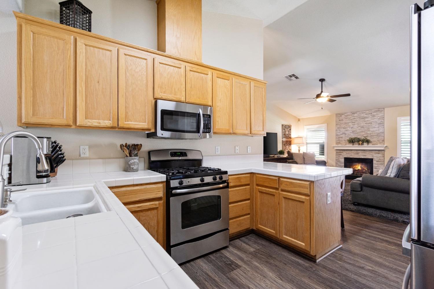 595 Quady Lane Madera, CA 93637 - Photo 13 of 25 a kitchen with a stove a sink and a microwave