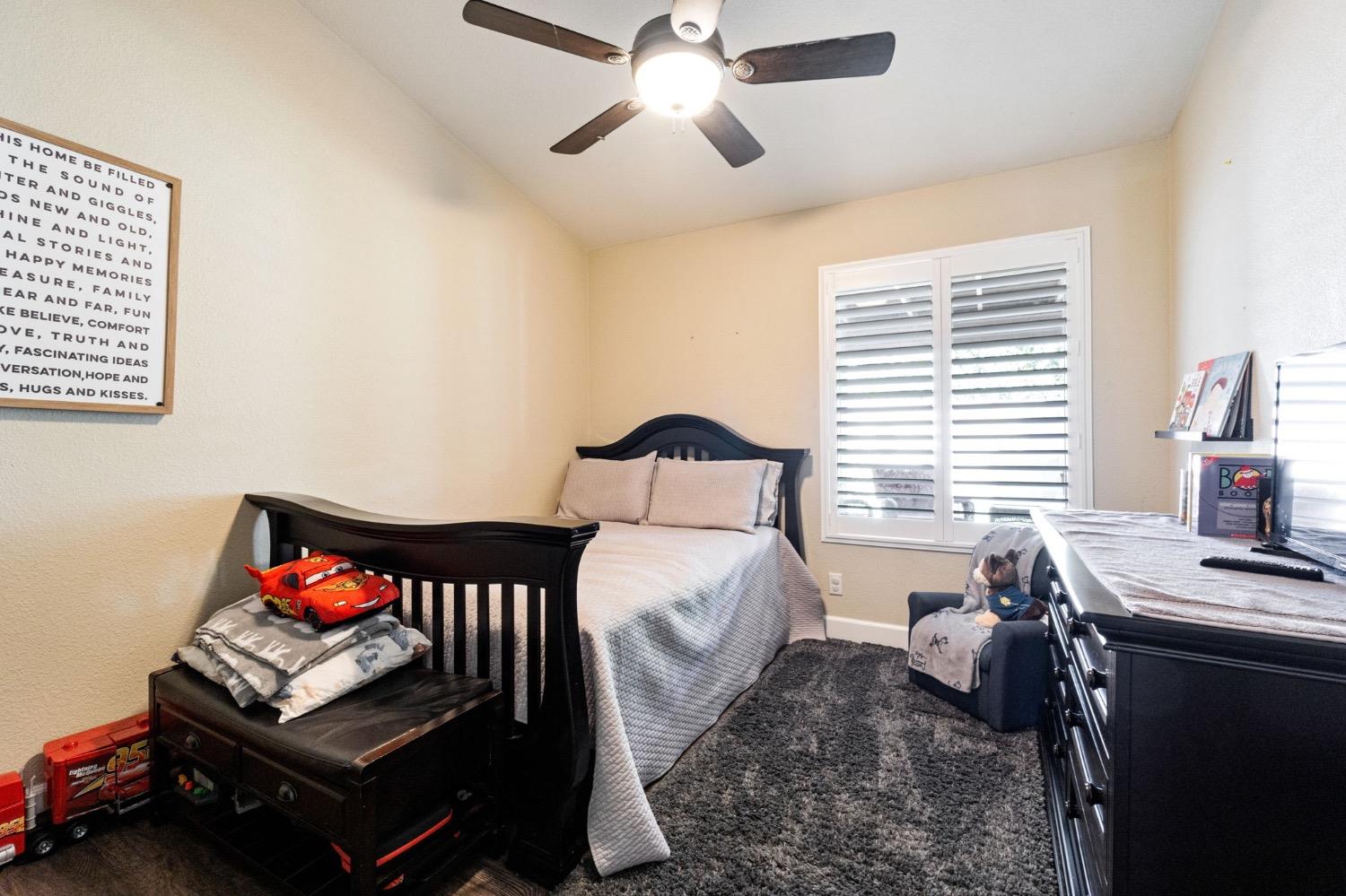 595 Quady Lane Madera, CA 93637 - Photo 17 of 25 a bedroom with a bed and a chandelier