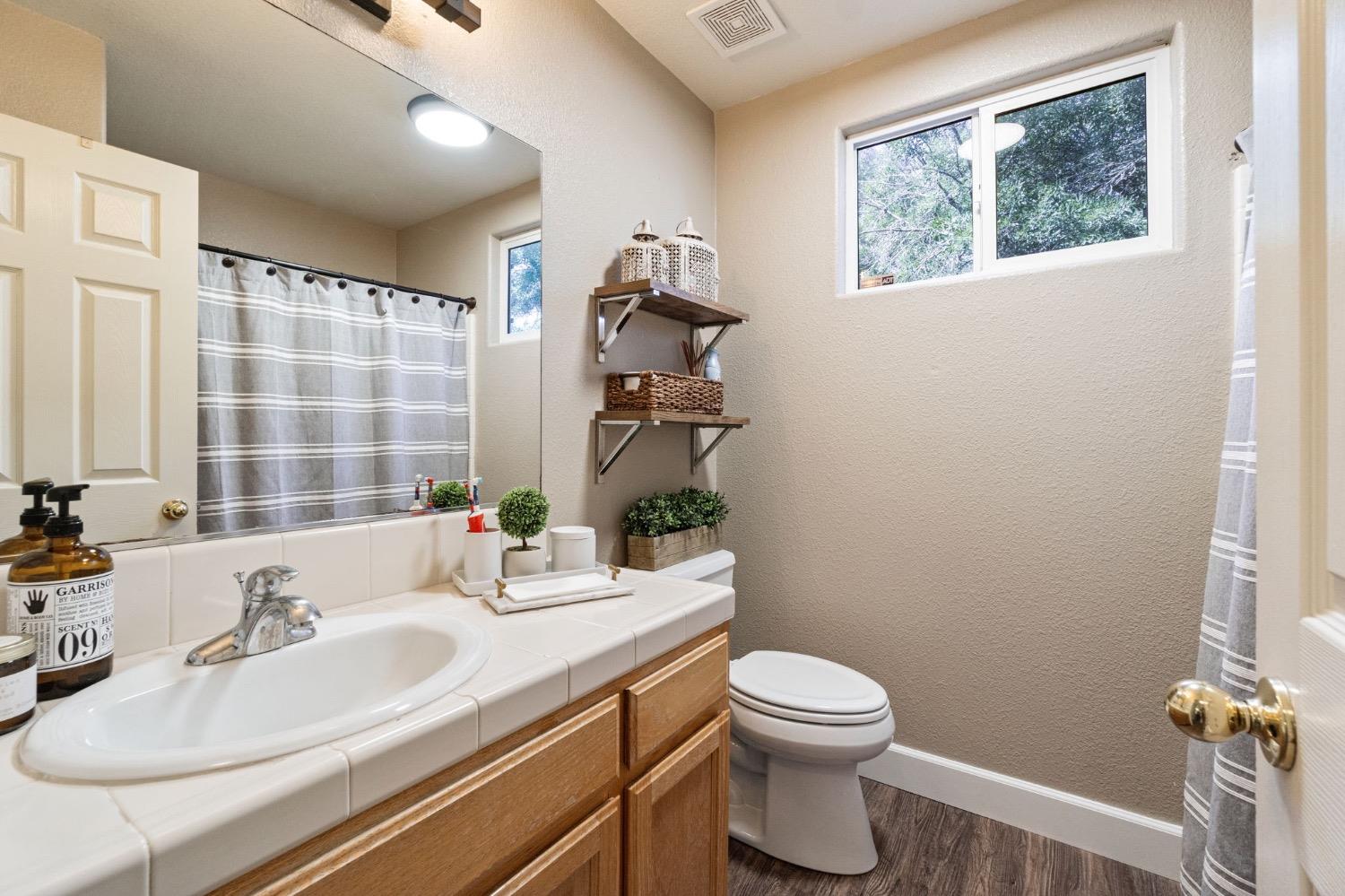 595 Quady Lane Madera, CA 93637 - Photo 18 of 25 a bathroom with a sink a toilet and shower